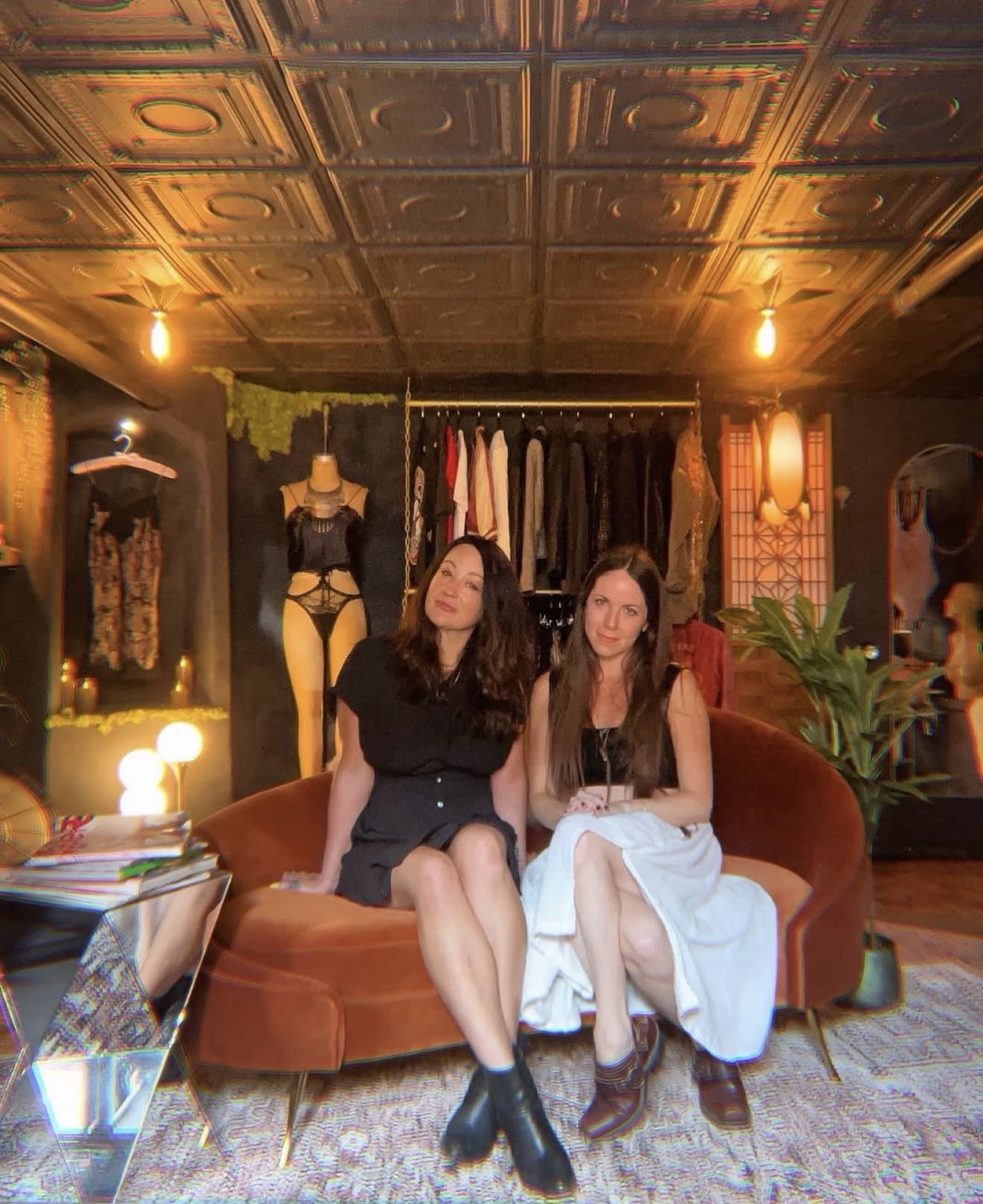 Jenna and Clare seated together on the velvet sofa at Hidden Gem on opening day