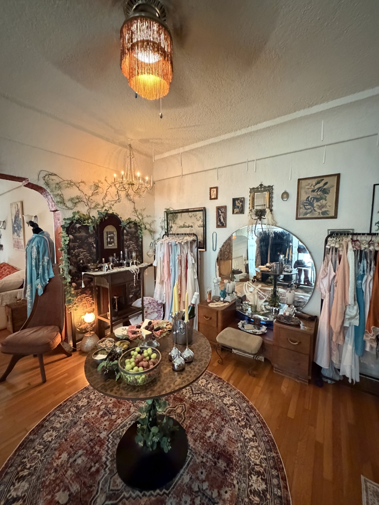 The Last Light salon layered with pastel vintage lingerie, mirrors and a chandelier