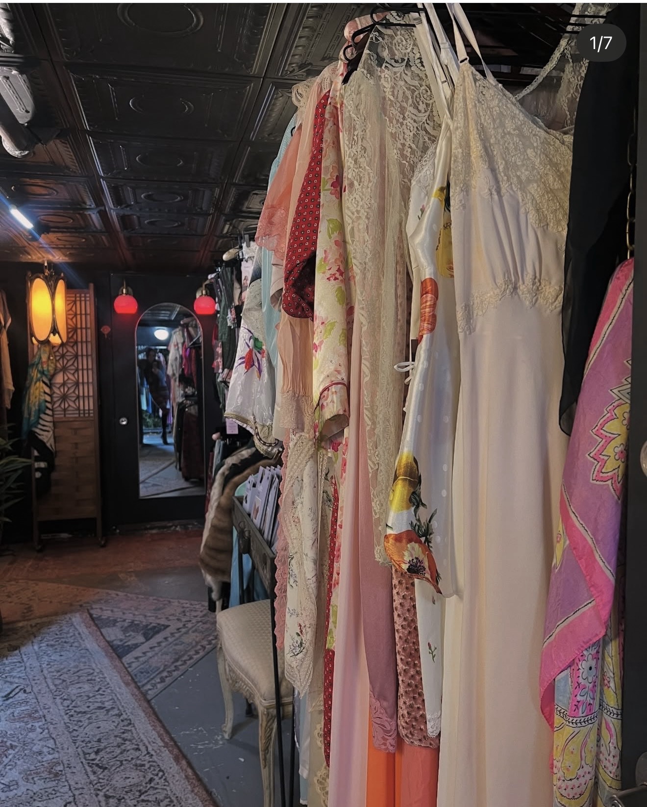 The wardrobe room at Hidden Gem in Hudson, rails of vintage clothing in moody light